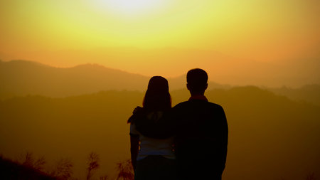 Silhouette of a lovely couple at sunset in the mountains.
