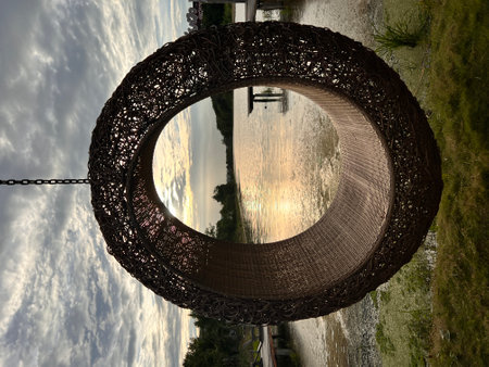 Woven rattan swing with the view of river at sunset.の写真素材