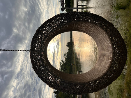 Woven rattan swing with the view of river at sunset.の写真素材