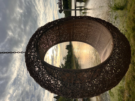 Woven rattan swing with the view of river at sunset.の写真素材