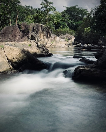 Long exposure of the rushing water over rock at Kaeng Som Maew Queen Sirikit forest park,...