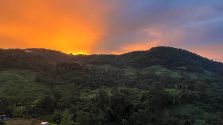 Panoramic view of mountain range under colorful blue and orange after sunset.の写真素材