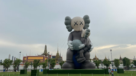 May 22 2025, Bangkok, Thailand : Tourist gather at Sanam Luang where a giant KAWS inflatable sculpture stand against the backdrop of Grand Palace's iconic Thai architecture.の写真素材