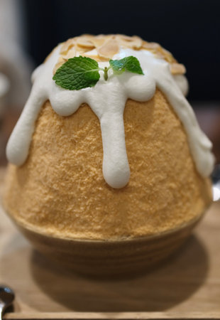 Thai tea shaved ice delights, or bingsu Thai tea on wooden table.の写真素材