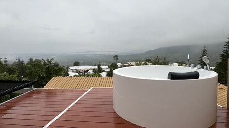 Outdoor bathtub on the terrace with mountain view at sunset.の写真素材