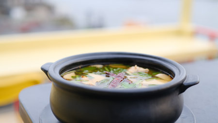 Chinese soup with pork and vegetables in a pot on the terrace