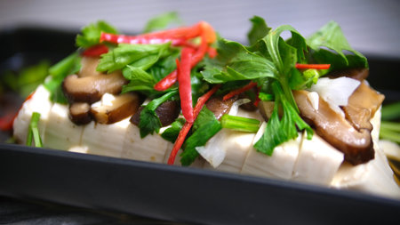 Steamed tofu with with mushroom and vegetable in soy sauce on black backgroundの写真素材