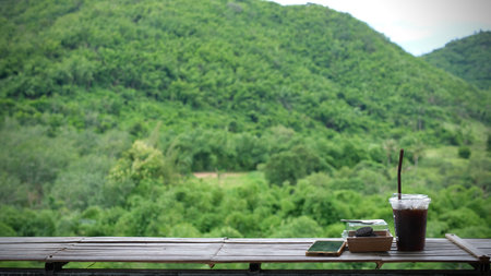 A glass of ice coffee with mountain view.の写真素材