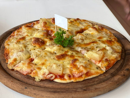 Table top view hawaiian pizza on wooden plate.の写真素材