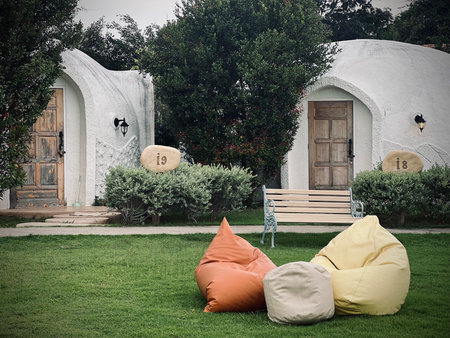 Ratchaburi, Thailand : Unique dome shaped resort among green tree, featuring a grassy lawn with colorful bean bags for relaxation at IGLOO Suanphueng resort.の写真素材