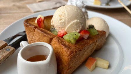 Honey toast with ice cream and fresh fruits on white plate