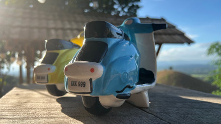 Pair of toy ceramic scooter on the wooden floorの写真素材