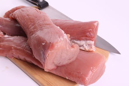 Fillet of pork on a cutting board on a withe isolated background with copy spaceの写真素材