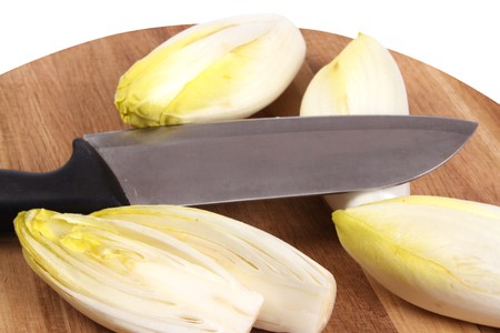Chicory on a cutting board on a white isolated background with copy spaceの写真素材