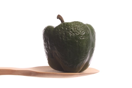 Bell pepper simply offered on a wooden spoon isolated on a white background の写真素材
