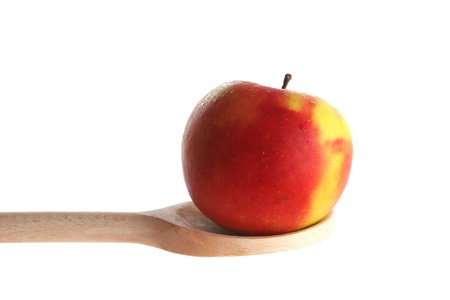 Apple on a wooden spoon isolated against a white backgroundの写真素材