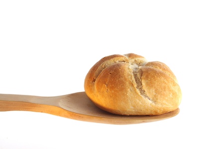 Bun on a wooden spoon against a white backgroundの写真素材