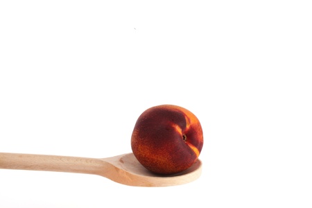 Apple on a wooden spoon isolated against a white backgroundの写真素材