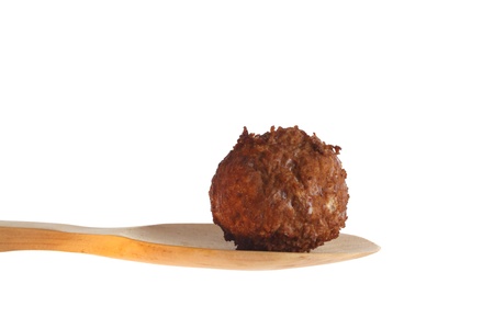 Fresh baked meatball on a wooden spoon aginst a white backgroundの写真素材