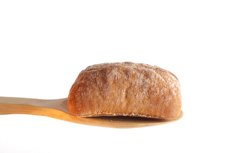 Bun on a wooden spoon against a white backgroundの写真素材