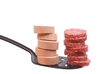Sausage on a spoon against a white background