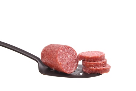 Sausage on a spoon against a white backgroundの写真素材
