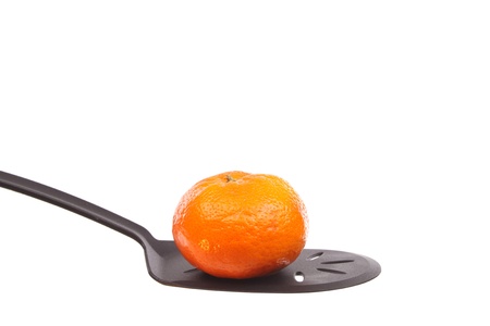 Tangerine on a spoon against a white backgroundの写真素材