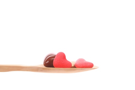 Candy simply offered on a wooden spoon isolated on a white background の写真素材