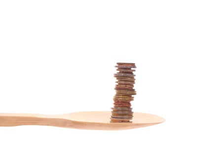 money simply offered on a wooden spoon isolated on a white background の写真素材