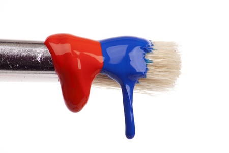 paint brush dripping with different coloured paintsの写真素材