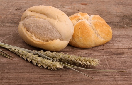 Bread and wheat on an old rustic wooden table