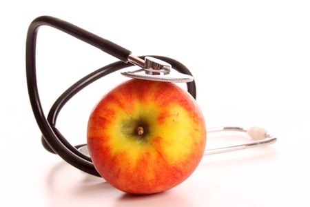 An apple being investigated bij a stethoscopeの写真素材