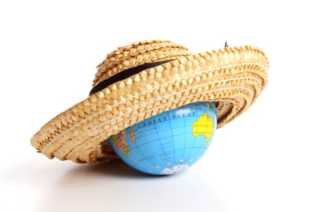 Straw hat covering a globe for the holidaysの写真素材