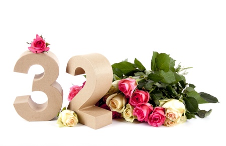 Number of age in a colorful studiosetting,surrounded with rosesの写真素材