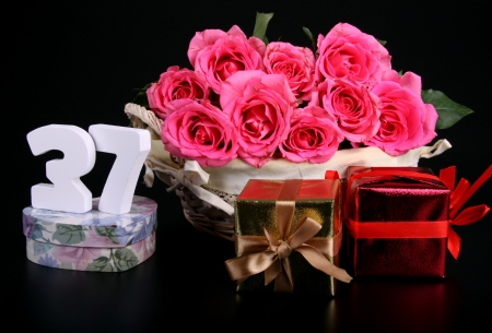 Number of age in a colorful studio setting with pink roses against a black backgroundの写真素材