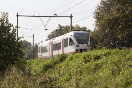 Train travels over a small dike in Limburg, Netherlands