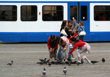 Netherlands, Amsterdam,june 2016: Children feeding doves on the Dam squareのeditorial素材