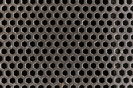 Large casted iron grating covers a sewer in an old buildingの写真素材