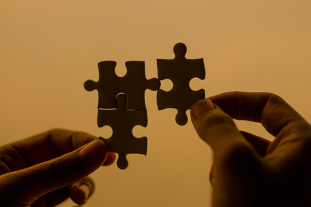 Silhouette Woman hands connecting couple puzzle piece against sunrise effect, businesswoman holding...