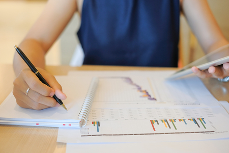 Businesswoman using tablet for analysis maketing plan, Accountant calculate financial report, computer with graph chart.  Business, Finance and Technology conceptsの写真素材