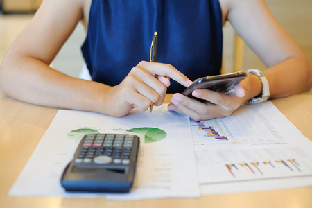 Businesswoman using smartphone for analysis maketing plan, Accountant calculate financial report, computer with graph chart.  Business, Finance and Technology conceptsの写真素材