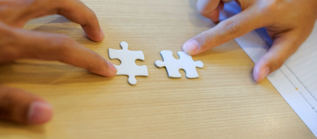 Businessman and Businesswoman Hand connecting couple puzzle piece. Teamwork, Partnership, successful, goals and strategy conceptsの写真素材