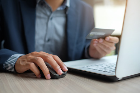 Businessman holding credit card and using laptop for online shopping while making orders via the Internet. business, technology, ecommerce and online payment conceptの写真素材