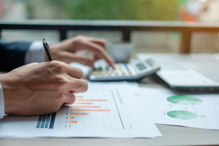 Businessman analysis maketing plan, Accountant calculate financial report, computer with graph chart.  Business, Finance and Accounting conceptsの写真素材