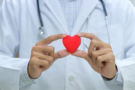 Male Doctor with stethoscope hand holding red heart shape in the hospital. Healthcare and Healthy Insurance conceptsの写真素材