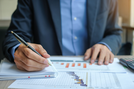 Businessman analysis maketing plan, Manager calculate financial report and graph chart.  Business, Finance and Accounting conceptsの写真素材