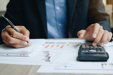 Businessman using calcultor for analysis maketing plan, Manager calculate financial report and graph chart.  Business, Finance and Accounting conceptsの写真素材