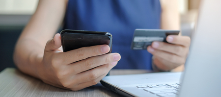 Businesswoman holding credit card and using smartphone for online shopping while making orders via the Internet. business, technology, ecommerce and online payment conceptの写真素材