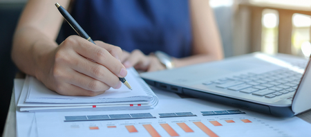 Businesswoman analysis maketing plan, Manager calculate financial report and graph chart.  Business, Finance and Accounting conceptsの写真素材