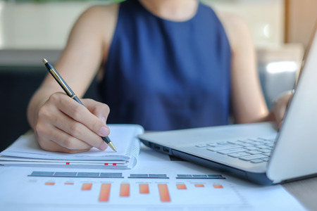 Businesswoman analysis maketing plan, Manager calculate financial report and graph chart.  Business, Finance and Accounting conceptsの写真素材